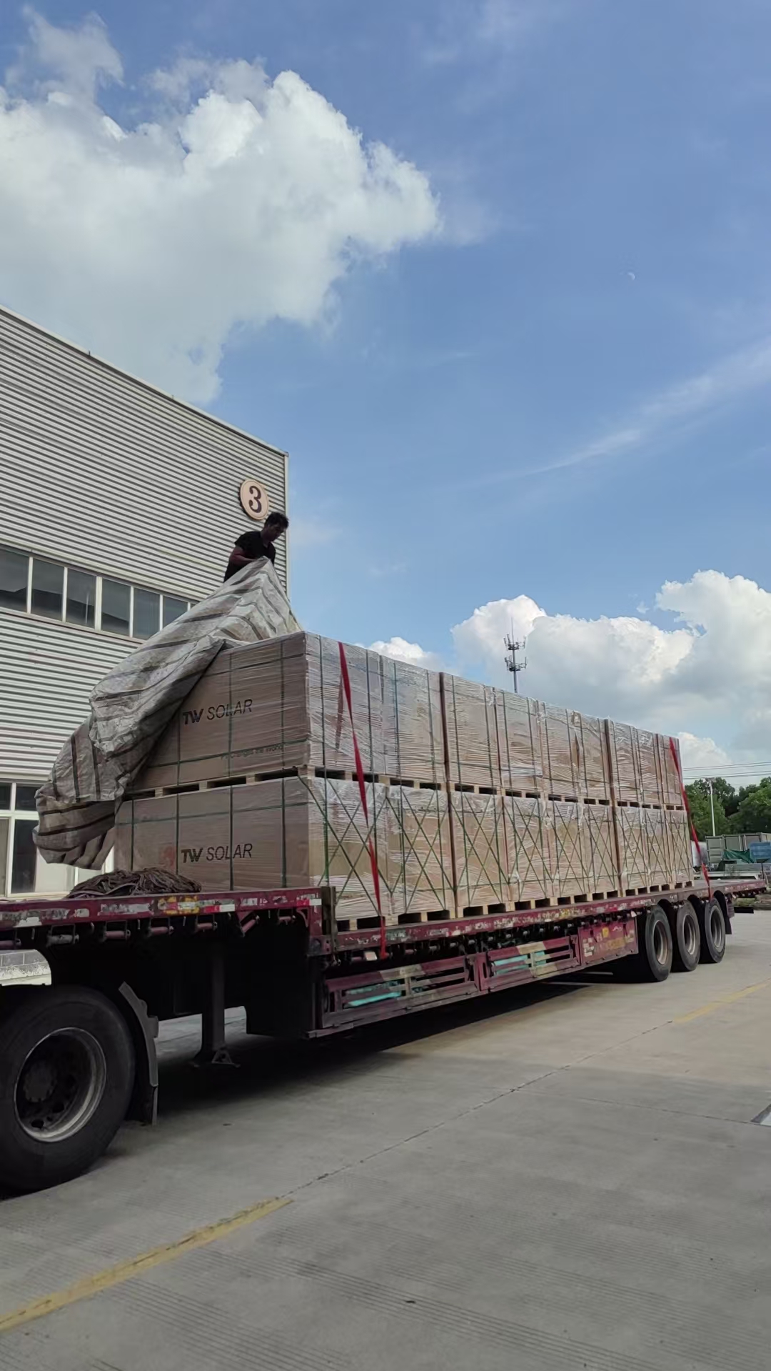 TW Solar panel pallets being strapped on flatbed truck